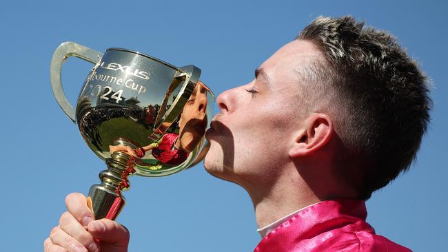 Robbie Dolan kissers the trophy after winning the Melbourne Cup. (Photo by Daniel Pockett/Getty Images)