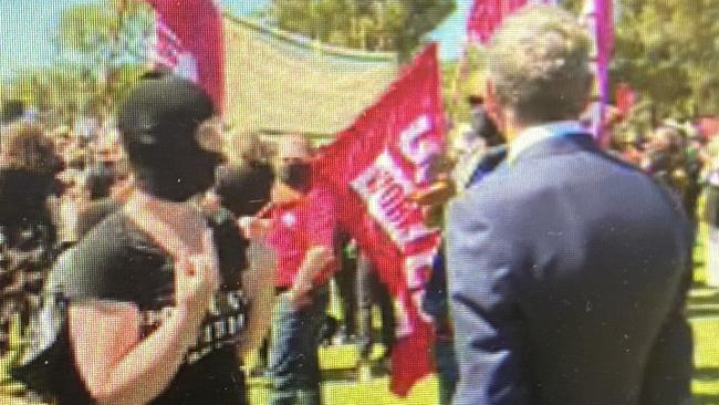 Chris Uhlmann is confronted by a balaclava-clad protester at last weeks March 4 Justice in Canberra.