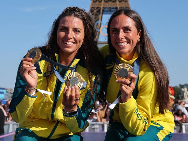 Australia's gold medallists and Jessica and Noemie Fox pose with their medals on stage at the Champions Park at Trocadero during the Paris 2024 Olympic Games in Paris on August 6, 2024, with the Eiffel Tower visible in the background. (Photo by Jack GUEZ / AFP)