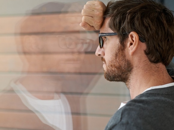 RendezView. Shot of a thoughtful young entrepreneur or extremely lonely man leaning against a glass window in his office. (Pic: iStock)