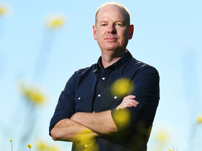 Tom Gleeson poses for a photograph in a Canola Field near Romsey, Friday, October 19, 2018. Tom Gleeson has started a petition to stop a mining exploration application near Romsey. (AAP Image/James Ross) NO ARCHIVING