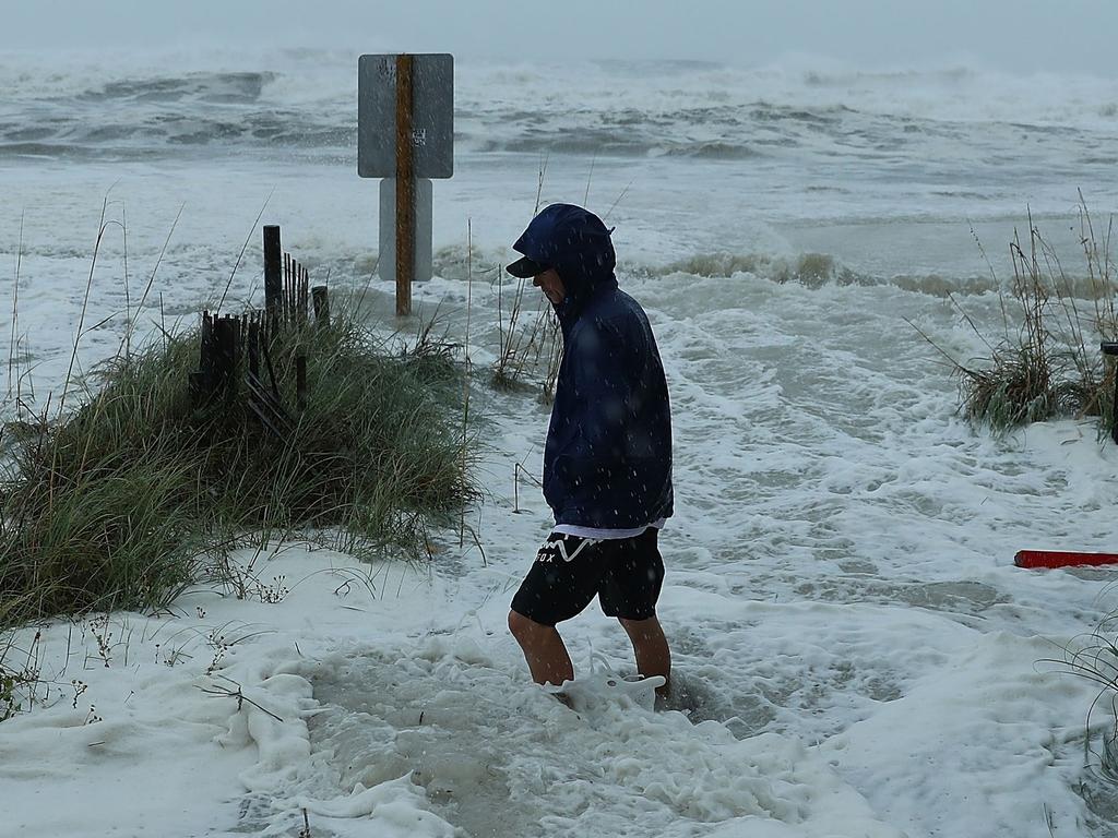 Cameron Sadowski walks along where waves are crashing onto the beach as the outer bands of Hurricane Michael hit Panama City Beach, Florida. Picture: Getty