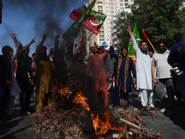 Pakistan Tehreek-e-Insaf party activists and supporters of Pakistan's former prime minister Imran Khan shout slogans next to a fire as they block a road during a protest against the arrest of their leader in Karachi. Picture: AFP