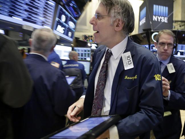 Trader Joseph Chirico, center, works on the floor of the New York Stock Exchange, Wednesday, Feb. 3, 2016. The stock market has given up an early gain and is trading lower at mid-morning Wednesday as investors give a thumbs-down to a number of corporate earnings reports, including steep cutbacks at Yahoo. (AP Photo/Richard Drew)