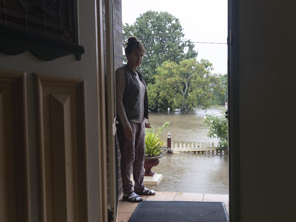 Windsor resident Kelly Miller shows concern as flood waters reach her workplace, a 100 year old property near the Windsor CBD. Picture: Getty