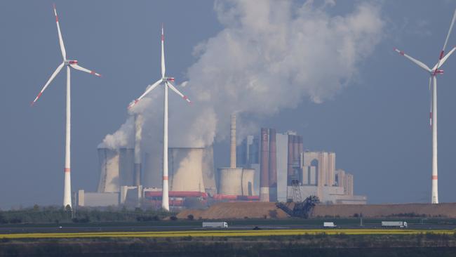 Wind turbines spin as steam rises from the Neurath coal-fired power station, which is supplied with lignite coal from nearby Garzweiler II. Picture: Getty Images