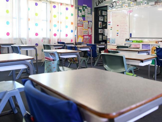 An empty classroom is seen at a primary school in Brisbane, Monday, March 30, 2020. The Australian Government has announced even tighter restrictions around social gatherings, and boosted stimulus spending, in attempts to fight off the coronavirus and its effects on the economy. (AAP Image/Dan Peled) NO ARCHIVING