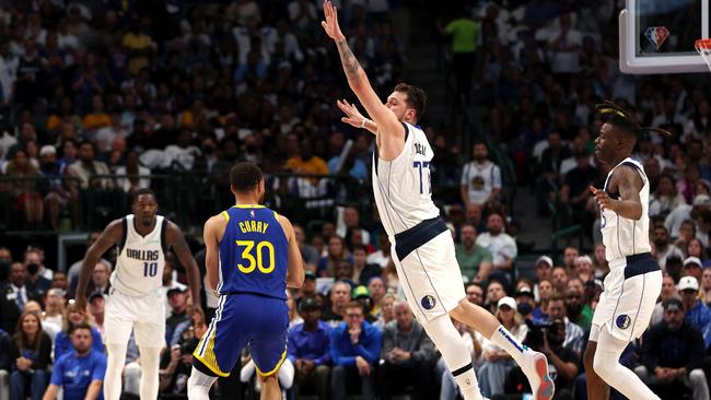 DALLAS, TEXAS - MAY 24: Luka Doncic #77 of the Dallas Mavericks jumps to stop a three point basket by Stephen Curry #30 of the Golden State Warriors during the second quarter in Game Four of the 2022 NBA Playoffs Western Conference Finals at American Airlines Center on May 24, 2022 in Dallas, Texas. NOTE TO USER: User expressly acknowledges and agrees that, by downloading and or using this photograph, User is consenting to the terms and conditions of the Getty Images License Agreement.   Tom Pennington/Getty Images/AFP == FOR NEWSPAPERS, INTERNET, TELCOS & TELEVISION USE ONLY ==