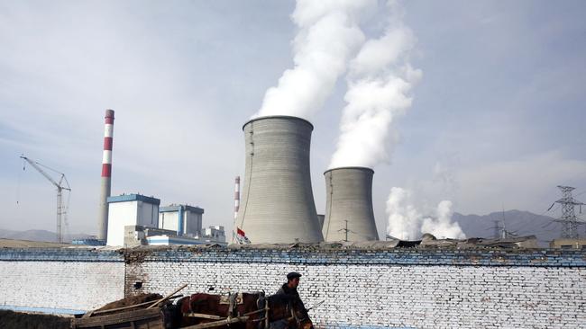 DATONG COUNTY, CHINA - JANUARY 31: (CHINA OUT) A farmer leads a cart walking past cooling towers of the coal-fired Datong County Thermal Power Plant on January 31, 2007 in Datong County of Qinghai Province, China. China has failed to make any headway with its efforts to protect the environment over the last three years as compared with other nations. A new government report ranks the country 100th on a list of 118 developing and developed countries in terms of "ecological modernization", the same ranking it held in 2004, according to the Modernization Report 2007 released by the Chinese Academy of Science. (Photo by China Photos/Getty Images)