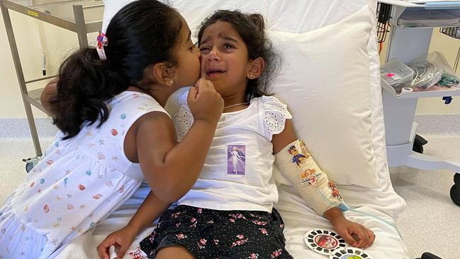 The youngest daughter of the ‘Biloela family’, Tharnicaa, is comforted by sister Kopika. Picture: Supplied