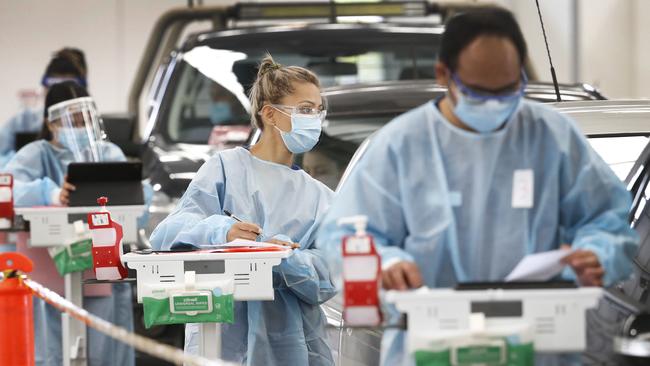 Nurse Shreesti Shrestha (centre) takes information from people being tested. Picture: David Caird