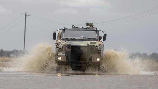 An Australian Army Bushmaster protected mobility vehicle drives on a flooded road on the way to conducting welfare checks with isolated communities near Lismore, Picture: Defence