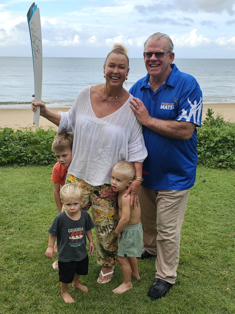 Olympian Lisa Curry with the Sydney Olympic torch, Fraser Coast Mates member Robert Garland and her grandkids.