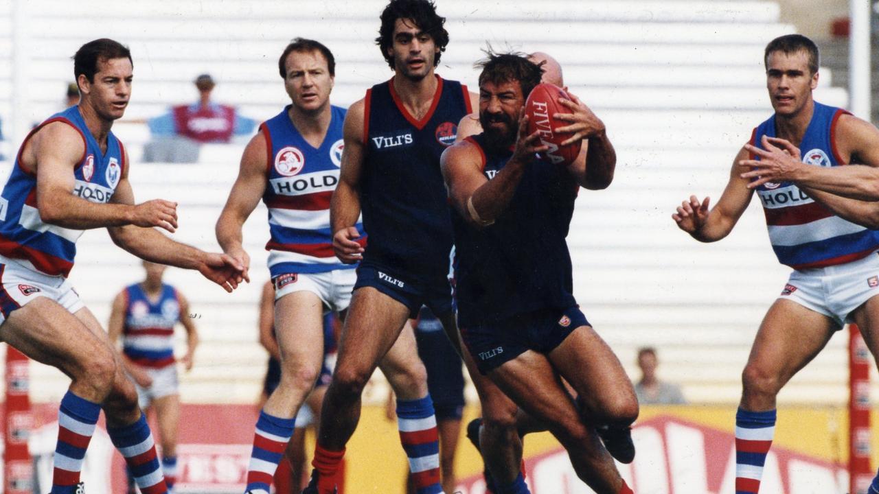 Footballer Garry McIntosh grabs possession in front of teammate Lachlan Bowman and opponent Scott Lee. SANFL football - Norwood vs Central District match at Football Park 30 Mar 1996. (Pic by staff photographer)