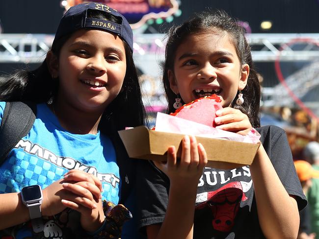 Friends (L-R) Milla Rose Nugroho (9) and Scarlett Beckett-Villanueva (8) enjoying the pink hotdog at the Royal Easter Show. Jane Dempster/The Sunday Telegraph.