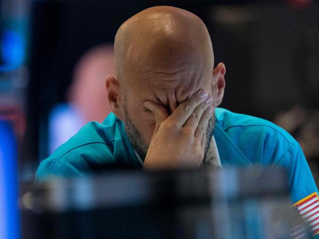 A trader wipes his eyes as he watches stock prices at the New York Stock Exchange August 23, 2019 in New York. - Wall Street stocks tanked Friday after President Donald Trump vowed a tough response to new Chinese tariffs, escalating the trade war between the world's top two economies amid rising fears of recession. The Dow Jones Industrial Average sank more than 600 points, or 2.4 percent, to 25,628.90, registering its fourth straight weekly loss. (Photo by Don Emmert / AFP)