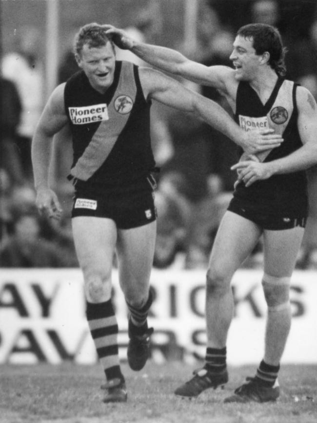 Glenelg’s John Fidge is congratulated by teammate Darren Mansell after booting a goal.