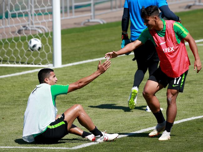 Daniel Arzani (R) helps teammate Tim Cahill off the turf. The pair are duelling for attacking minutes off the bench. Picture: Toby Zerna