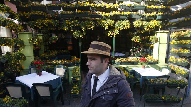 A waiter waits for guests in front of a restaurant in the Skadarlija bohemian quarter in Belgrade.