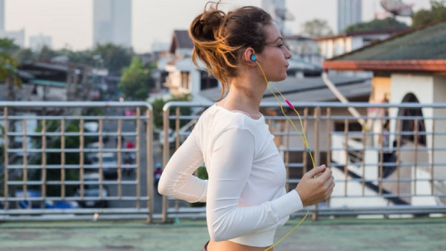 Woman Putting On Her Sport Bra Before Exercise by Stocksy