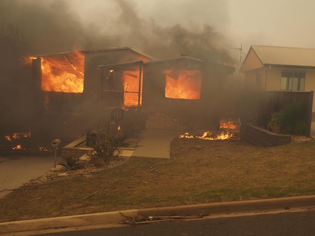 Flames eat up a house in Tathra. Picture: John Ford