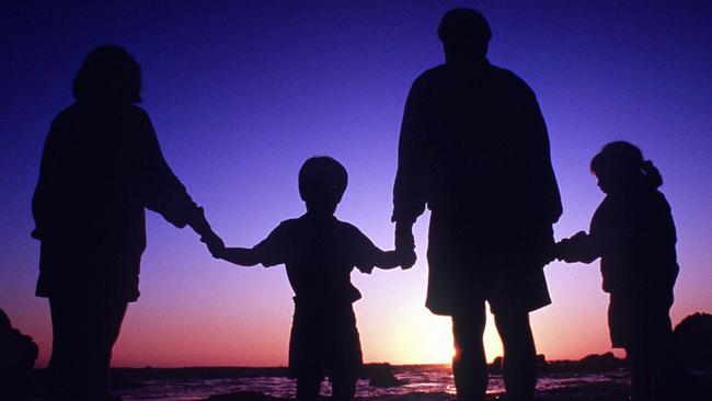 Undated. Silhouette of a generic family with parents and children holding hands. Beach. Sunset. People.