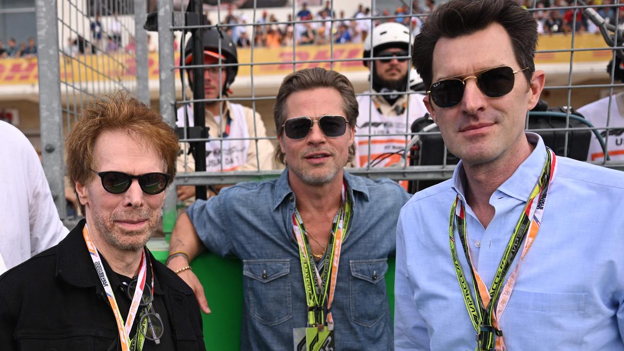 US film producer Jerry Bruckheimer, actor Brad Pitt and director Joseph Kosinski at last year’s United States Grand Prix. (Photo by Patrick T. FALLON / AFP)