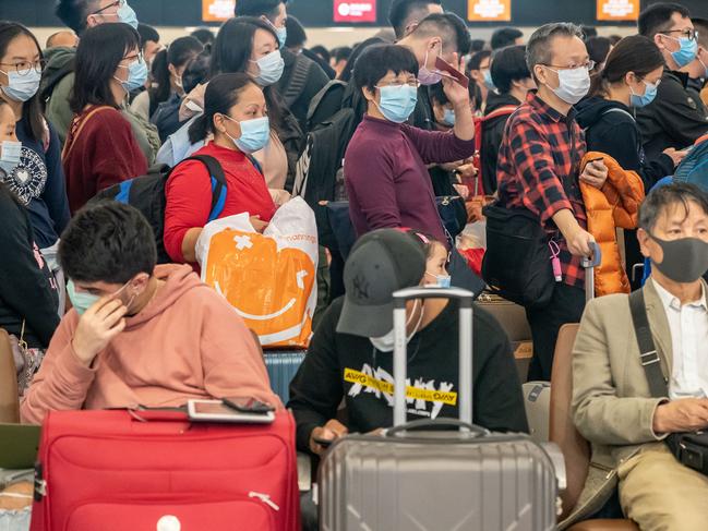 Travellers wearing face mask wait at the departure hall of West Kowloon Station in Hong Kong, China. Picture: Getty