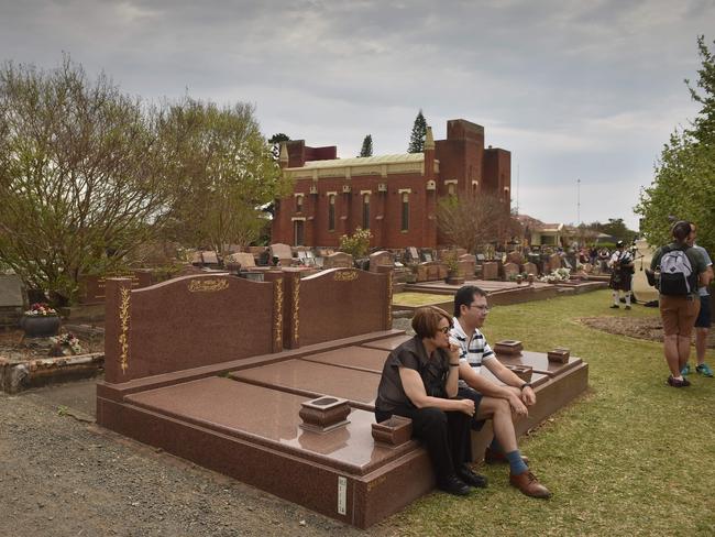 Visitors sit among the gravestones to at Rookwood cemetery in Sydney, which has become an unlikely tourist attraction. Picture: AFP/Peter Parks