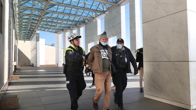 A man is handcuffed and led away by police from an Extinction Rebellion protest in front of Parliament House, in Canberra. Picture: NCA NewsWire / Gary Ramage