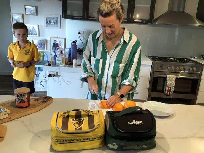 Angus, 9, looks on while Lauren prepares his school lunch.