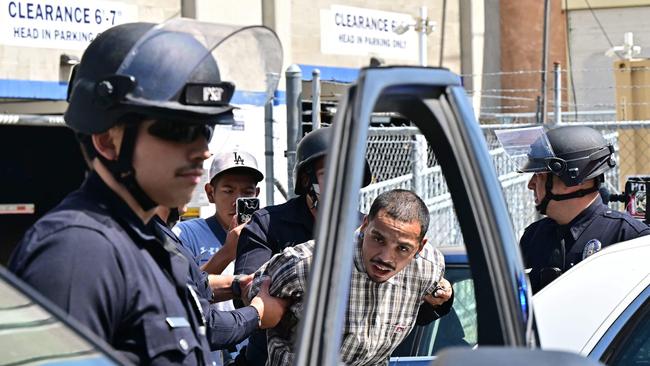A man is detained by the police near the Metropolitan Detention Centre. Picture: AFP