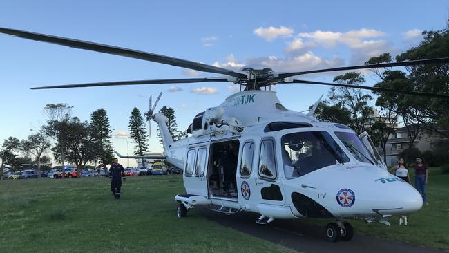 The NSW Ambulance helicopter landed on a reserve behind the Dee Why Surf Life Saving Club on Thursday evening after being called to assist the treatment a man who suffered suspected spinal injures in the nearby ocean pool. Picture: Manly Daily