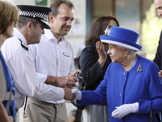 LONDON, ENGLAND - JUNE 16:  Queen Elizabeth II and Prince William, Duke of Cambridge (R) greet members of emergency services at the scene of the Grenfell Tower fire on June 16, 2017 in London, England. 17 people have been confirmed dead and dozens still missing, after the 24 storey residential Grenfell Tower block in Latimer Road was engulfed in flames in the early hours of June 14. Emergency services will spend a third day searching through the building for bodies. Police have said that some victims may never be identified.  (Photo by Dan Kitwood/Getty Images)