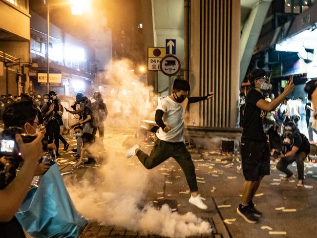 A protester attempts to kick a tear gas canister during a demonstration on Hungry Ghost Festival day in Sham Shui Po district. Picture: Getty