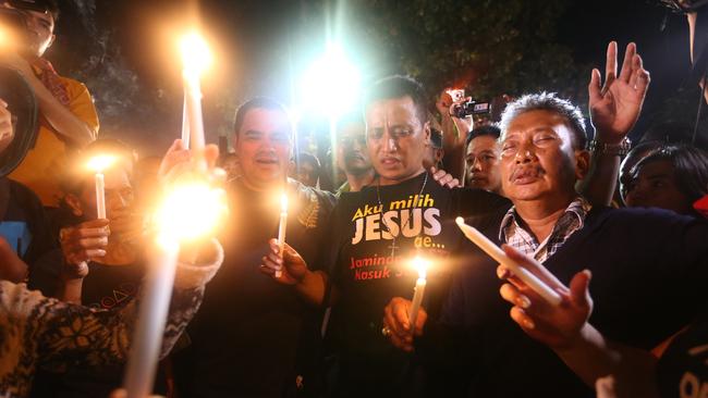 Supporters of Bali 9 Myuran Sukumaran and Andrew Chan light candles out the front of Nusakambangan Island Port just after midnight when the executions took place. Picture: Adam Taylor