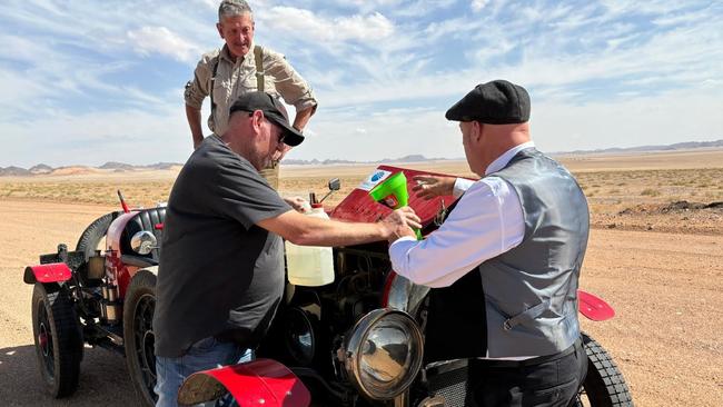 Team mechanic Tony Jordan tops up the radiator after “the Devil’s Anvil” sucked moisture from exposed drivers and the century old car.