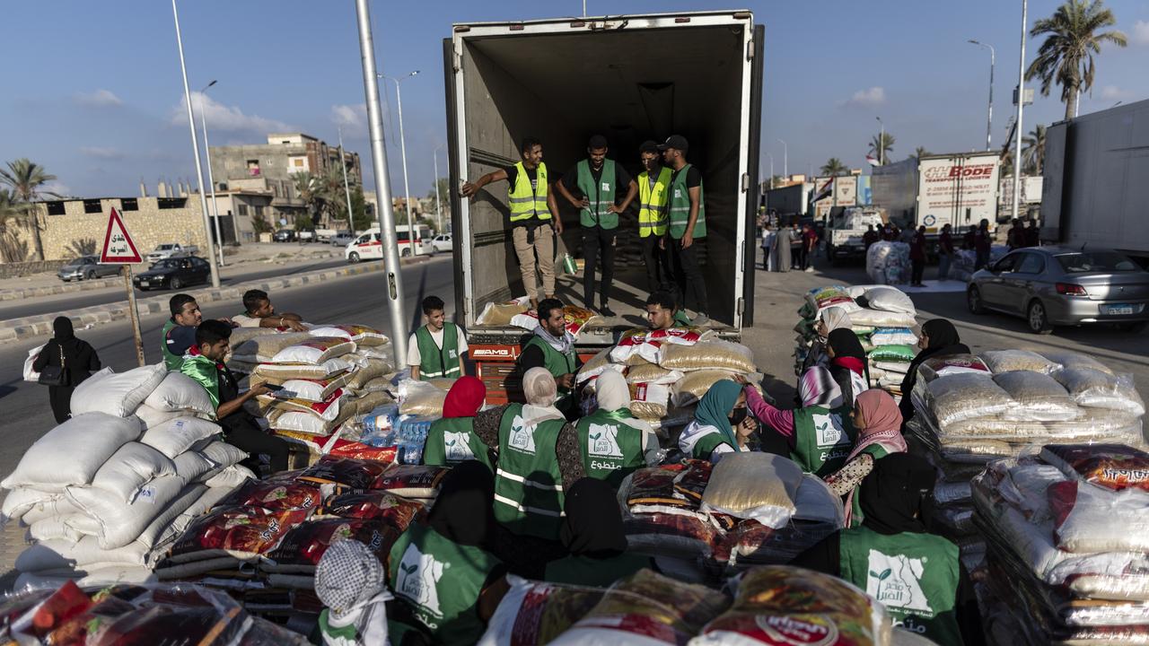 Volunteers load food and supplies onto trucks in an aid convoy headed for Gaza from Egypt. Picture: Getty Images