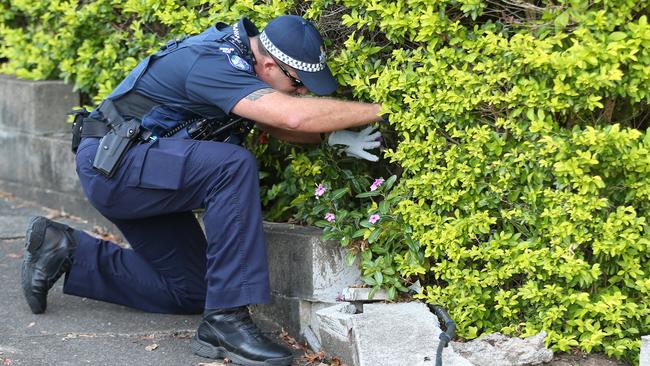 Queensland Police and forensic team scour the area around a unit complex. Pictures: Jack Tran