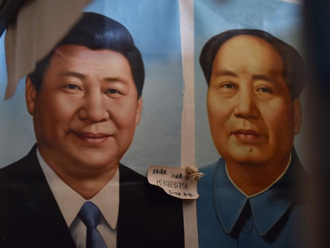 Painted portraits of Chinese President Xi Jinping, left,  and late communist leader Mao Zedong at a market in Beijing. China's Communist Party added President Xi Jinping's name to its constitution, confirming his status as the nation's most powerful leader. Picture: AFP