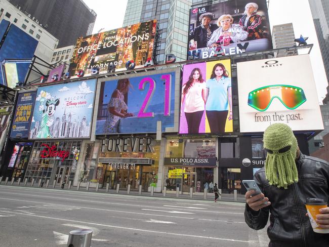 A New Yorker finds a novel way to protect himself against coronavirus while walking through an almost empty Times Square. Picture: AP