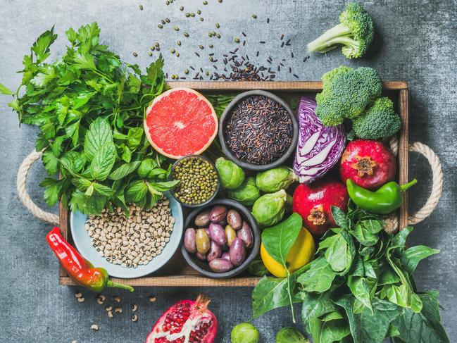 Vegetables, fruit, seeds, cereals, beans, spices, superfoods, herbs, condiment in wooden box for vegan, gluten free, allergy-friendly, clean eating or raw diet. Grey concrete background and top viewIstock image for wellbeing in Gold Coast Eye