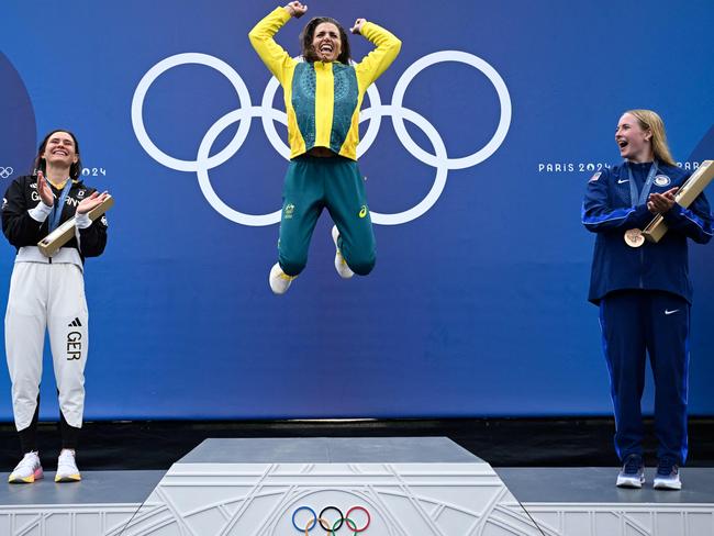 Silver medallist Germany's Elena Lilik (L) and bronze medallist US' Evy Leibfarth (R) applaud as gold medallist Australia's Jessica Fox celebrates on the podium during the medal ceremony after the women's canoe single final of the canoe slalom competition at Vaires-sur-Marne Nautical Stadium in Vaires-sur-Marne during the Paris 2024 Olympic Games on July 31, 2024. (Photo by Olivier MORIN / AFP)