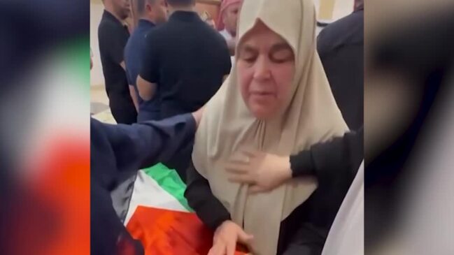 Wife of Hamas chief Ismail Haniyeh mourns next to his coffin