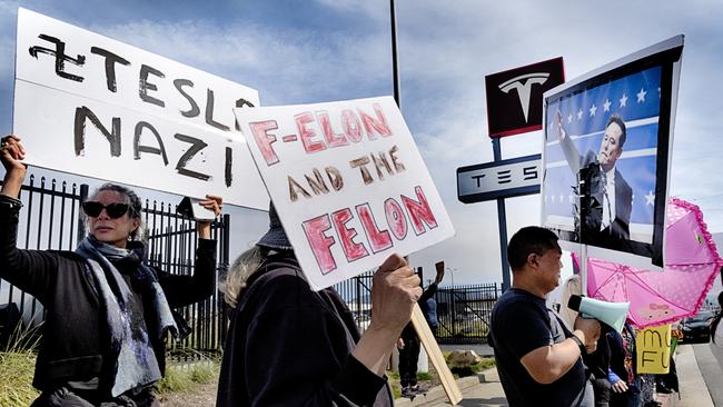 Protesters carrying signs and chant slogans protesting Elon Musk and President Donald Trump outside a Tesla showroom and service center in the North Hollywood. Picture: AP Photo/Richard Vogel