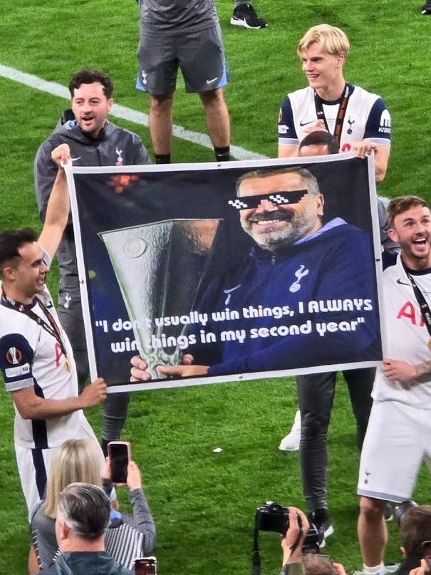 Tottenham's players hold up a banner with Postecoglou's famous quote.