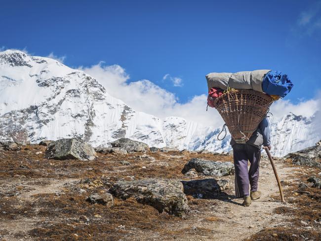 ESCAPE: INTREPID NEPAL .. Matt Johnston story .. a sherpa leads the way with his heavy load strapped to his head. Picture: iStock