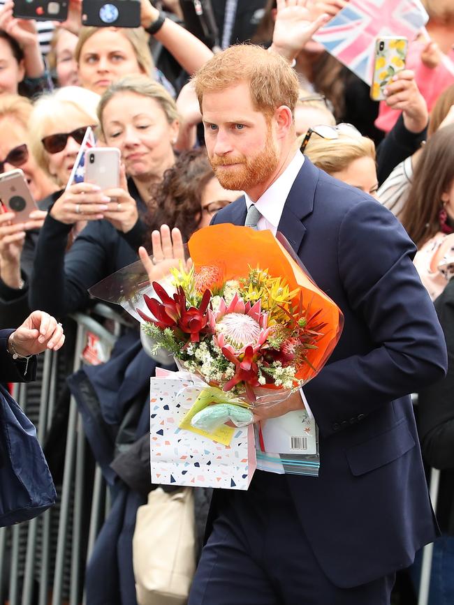 Prince Harry with gifts from the adoring crowd. Picture: Getty