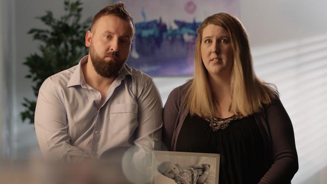 Catherine Hughes with her husband Greg, holding a photo of their son Riley, who died of whooping cough at just four weeks old. Picture: Supplied