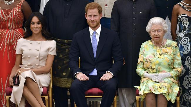 The Queen, Prince Harry and Meghan, Duchess of Sussex, pose for a group photo at the Queen's Young Leaders Awards Ceremony at Buckingham Palace in London.